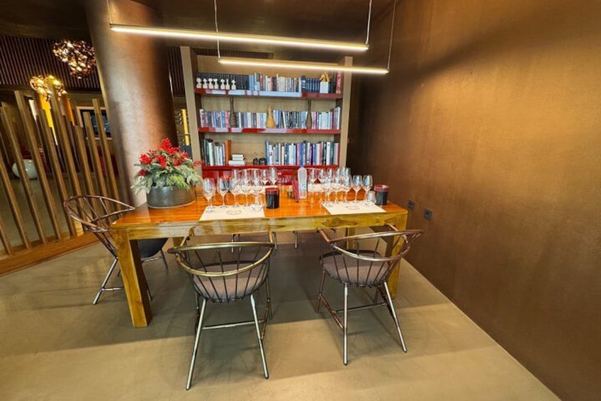 Un comedor moderno con una mesa de madera, sillas de metal y una estantería al fondo. 4