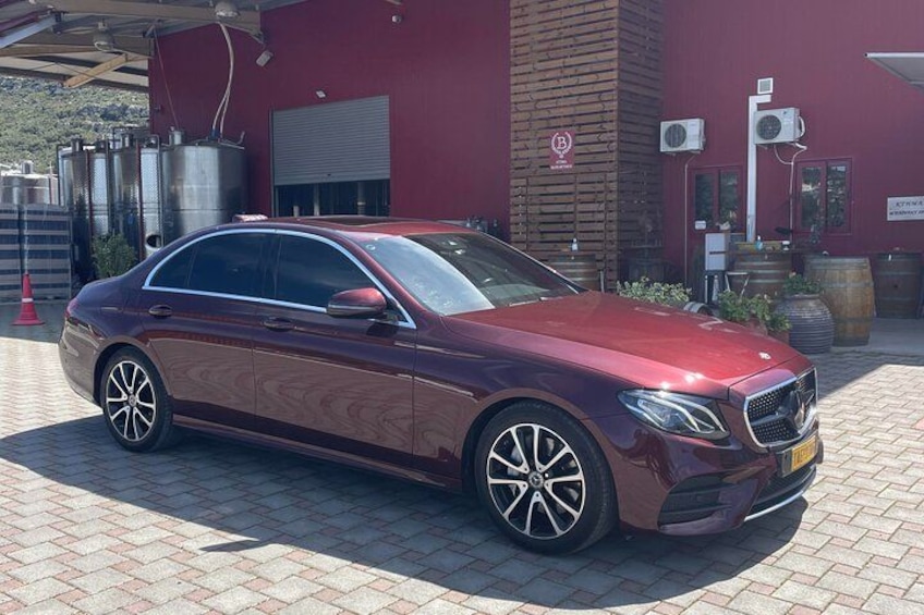 Une Mercedes-Benz de couleur bordeaux était garée devant un immeuble à la façade rouge. 4