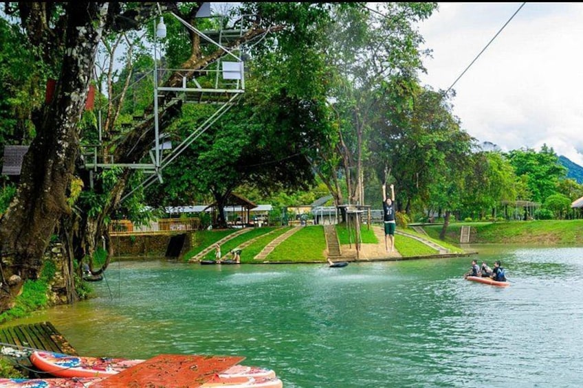 A river with a cable car system, a small boat, and a dock with canoes. 2
