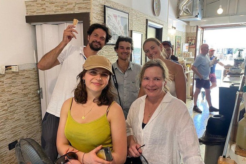 Eine Gruppe von Personen in einem Restaurant mit einer Theke und einem Ventilator. 2