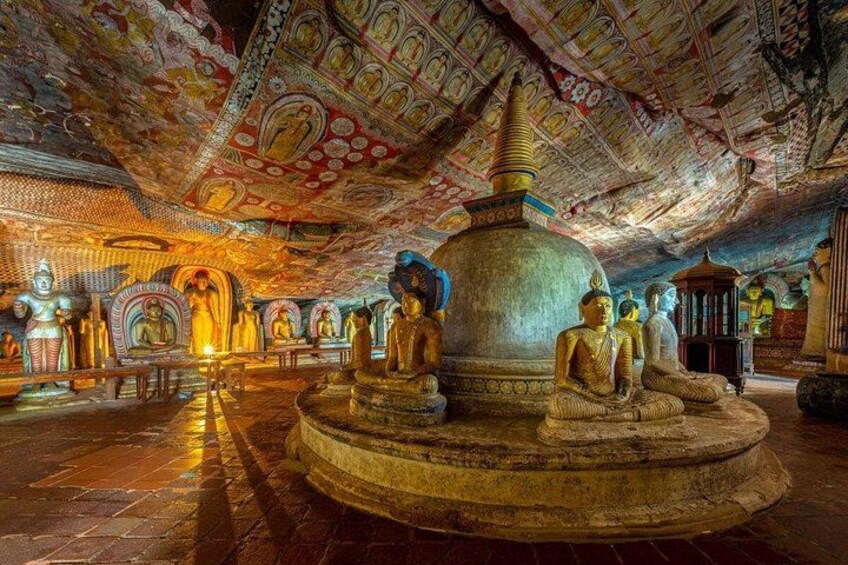 A temple interior with Buddha statues, intricate ceiling artwork, and a central stupa. 4