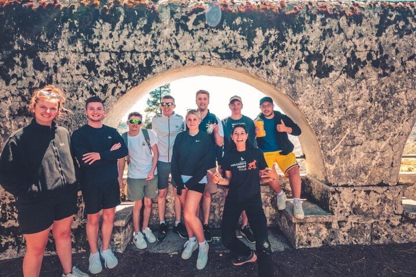 Un gruppo di persone davanti a un arco in pietra. 3