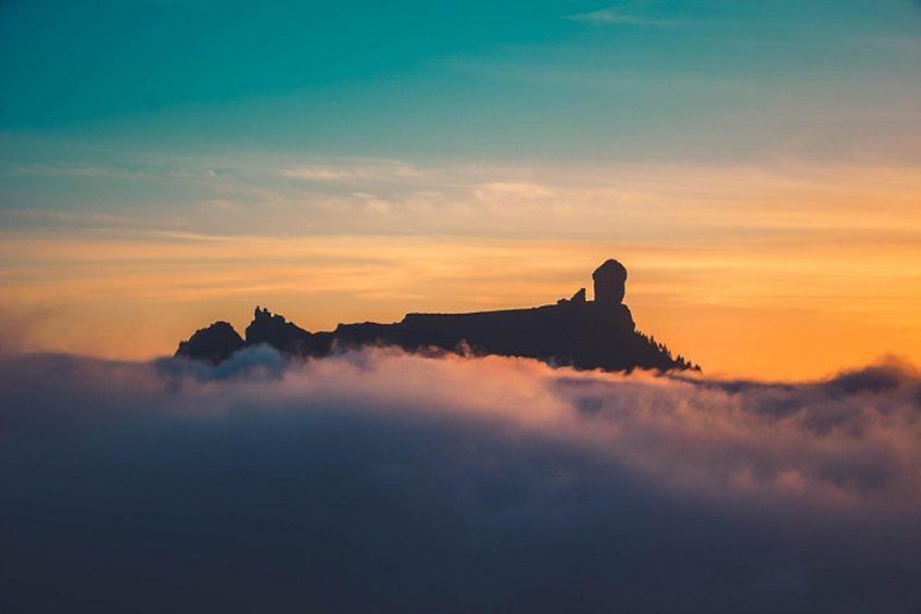La sagoma di una montagna con una struttura a cupola sulla cima, circondata da nuvole. 5