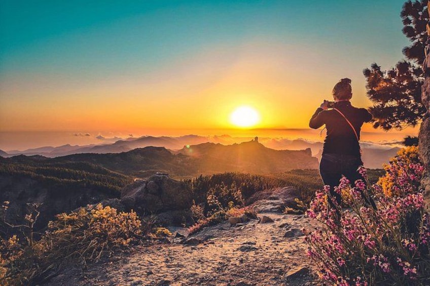 Una persona che fa escursionismo su un sentiero di montagna con un tramonto sullo sfondo. 1