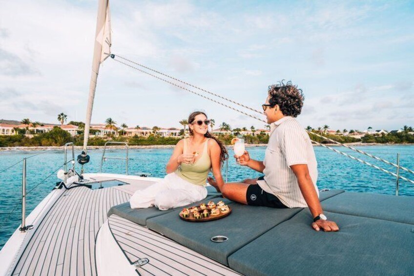 A couple on a sailboat with a view of a coastal town. 5