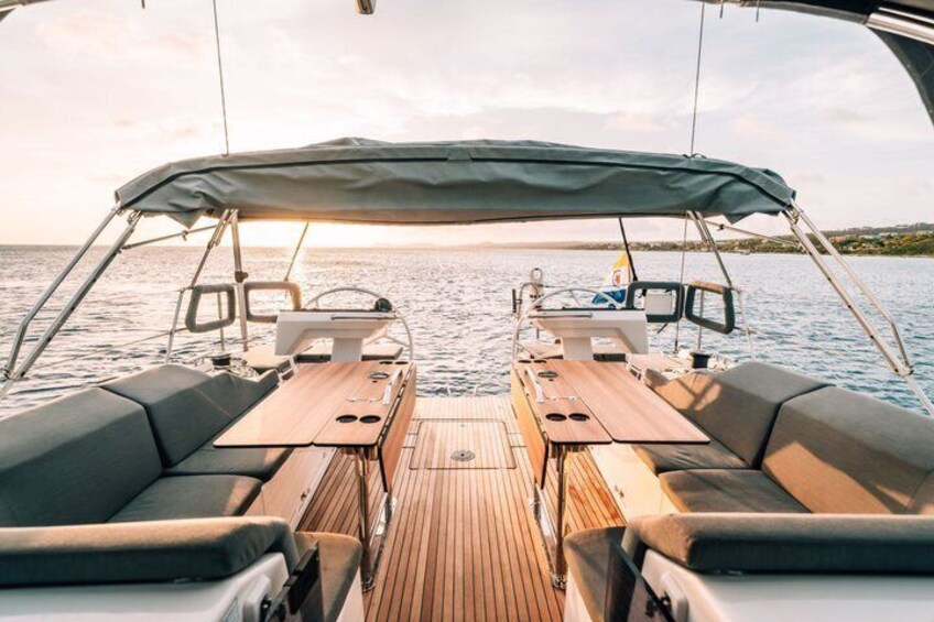 A boat deck with a covered seating area, a steering wheel, and a view of the water. 3
