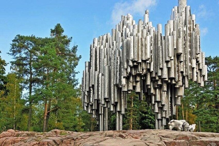 Eine einzigartige Skulptur aus vertikalen, zylindrischen Elementen in einer natürlichen Umgebung mit Bäumen und Felsen. 2