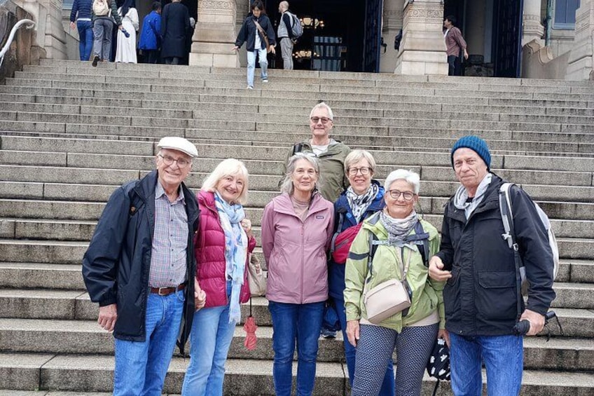 Un grupo de personas sobre escalones de piedra frente a un edificio de arquitectura clásica. 3