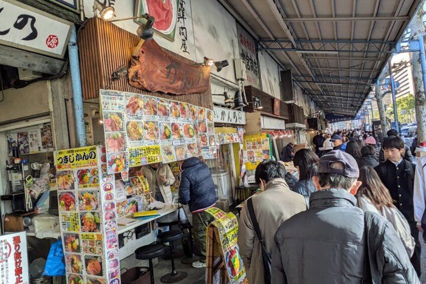 Un mercado de comida callejera con puestos de comida y gente. 4