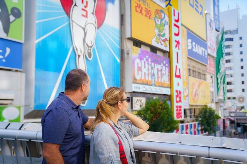 A couple standing by a railing with a cityscape in the background. 5