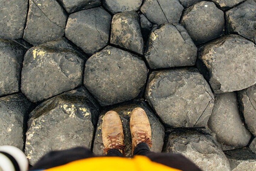 A pair of brown hiking boots on a rocky surface. 3
