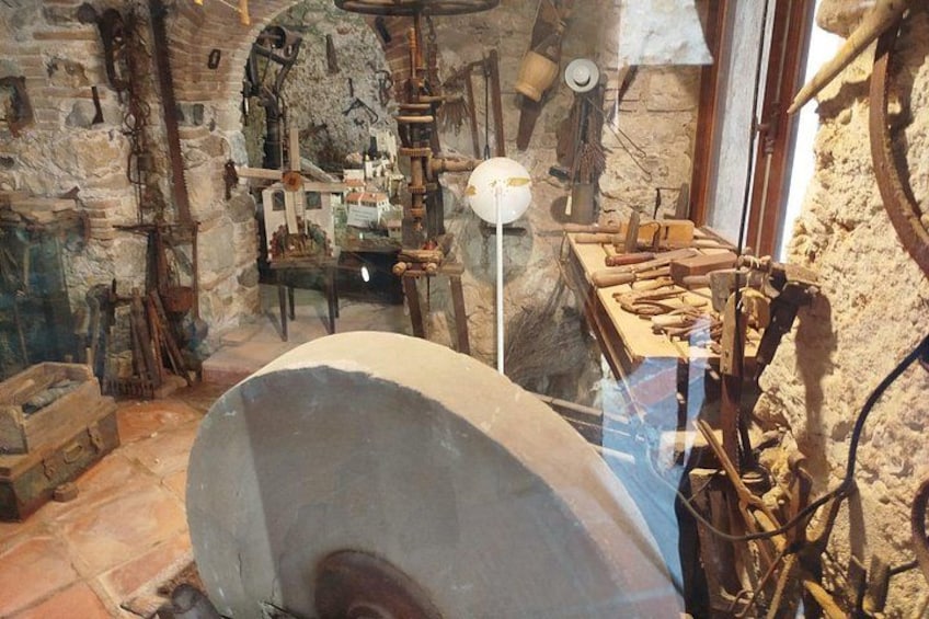A stone building with a large stone oven, wooden tools, and a rustic interior. 1