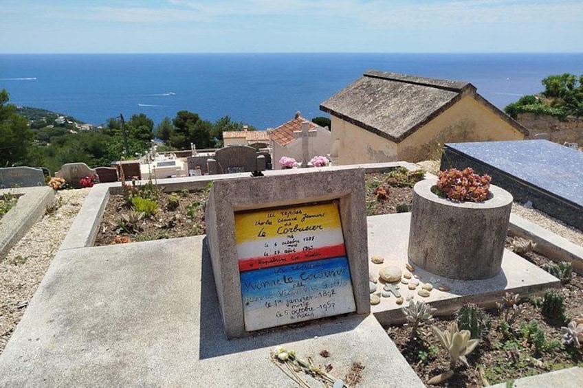 A cemetery with headstones, a sign with text, and a view of the sea. 4