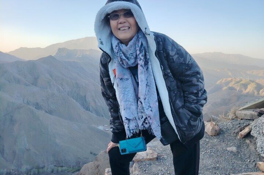 A person standing on a mountain ridge with a scenic view of distant mountains. 5