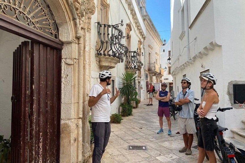 A narrow street with historic buildings, a gate, and a bicycle. 3