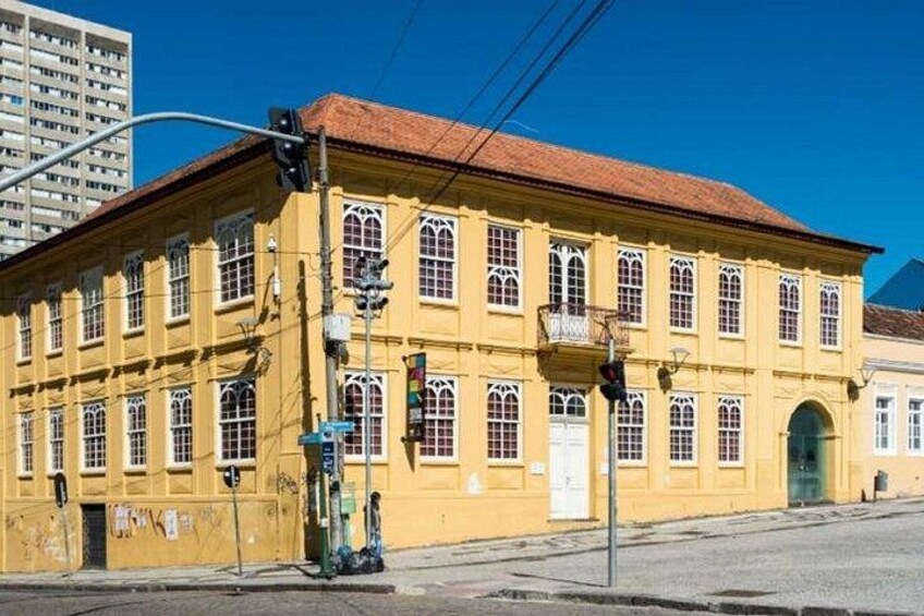 A yellow building with arched windows and a red roof. 5