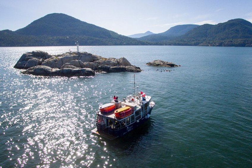 Un bateau sur un lac, avec des îles rocheuses et des montagnes en arrière-plan. 4