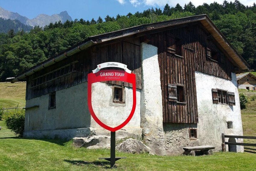A rustic mountain lodge with a sign indicating a 'Grand Tour.' 3