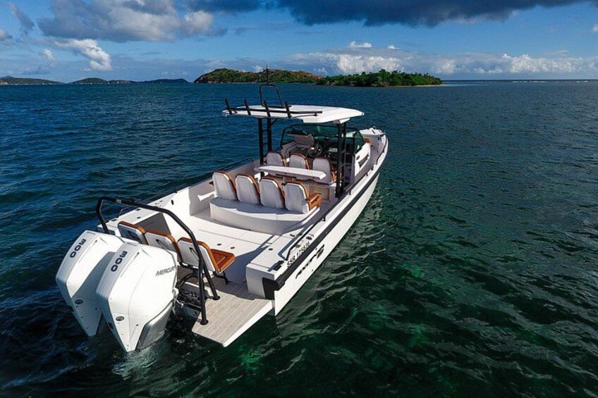 Een motorboot op kalm water, met een heldere lucht en land in de verte. 4