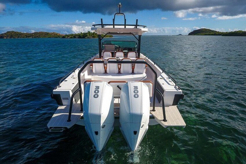 Een motorboot met twee buitenboordmotoren, een cabine en een kielzog. 2
