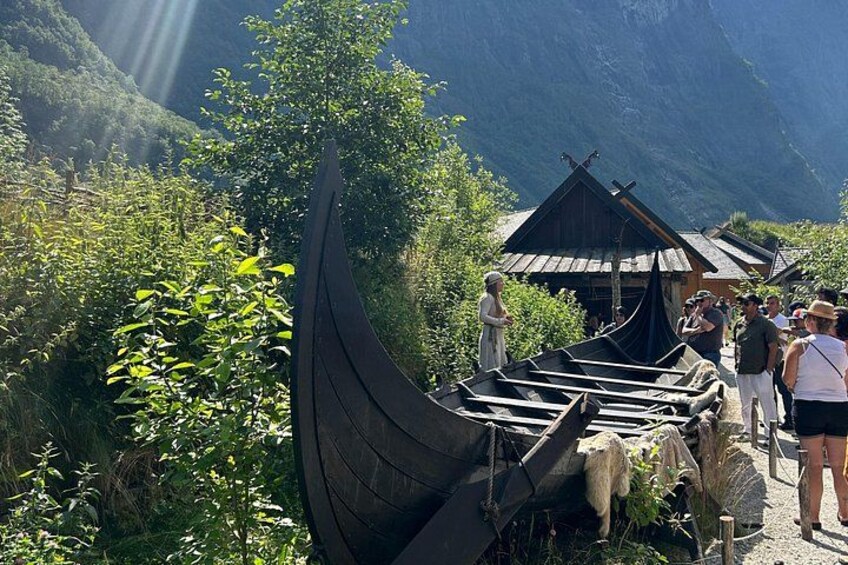 Un bote tradicional, una estructura de madera y un paisaje montañoso. 2