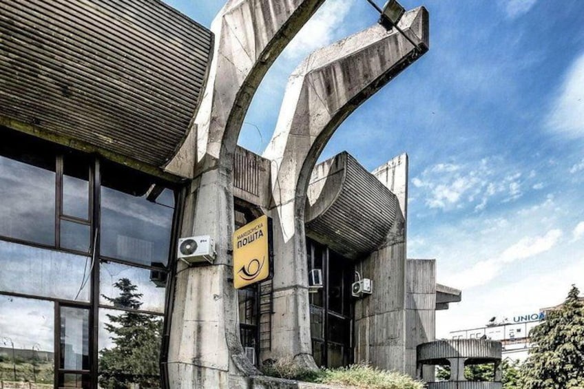 A building with a unique architectural design, featuring curved concrete structures and a large window. 3