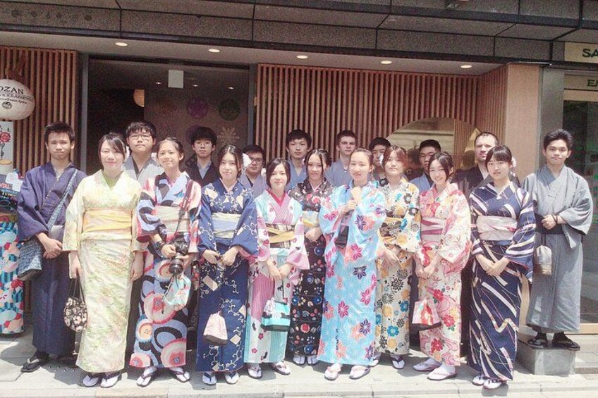 En grupp människor klädda i traditionella japanska kimonos som står framför en byggnad. 2