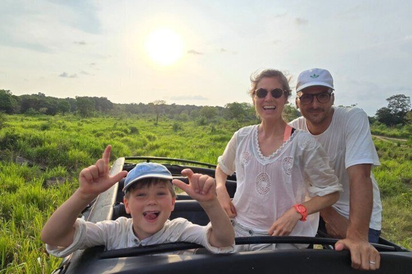 Eine Familie fährt in einem Cabriolet über eine Wiese, der Himmel ist blau. 2