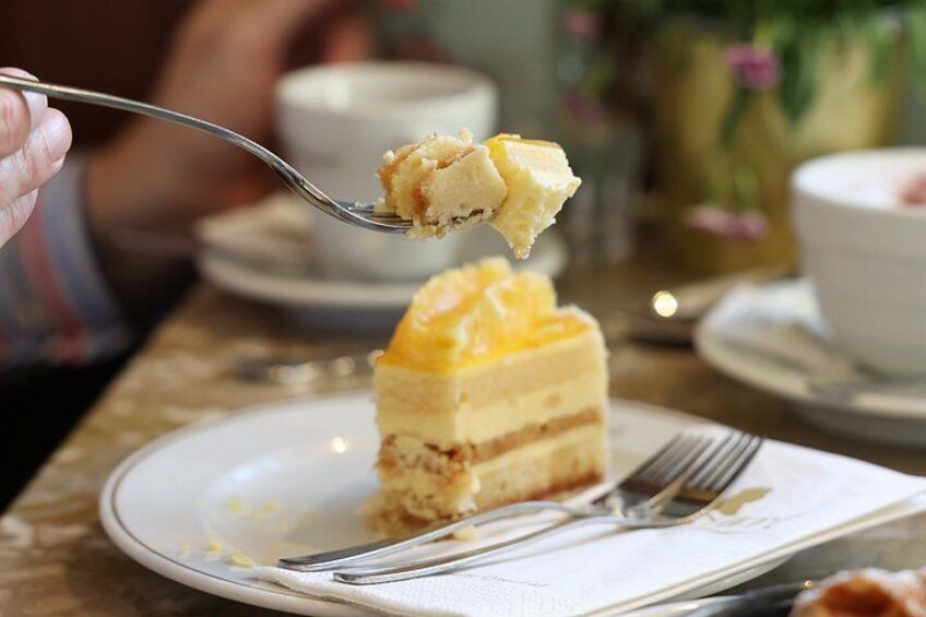 A slice of yellow cake on a plate with a fork. 3