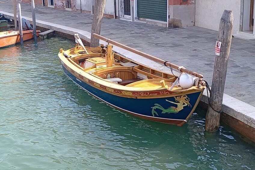 Ein hölzernes Boot mit Drachenmuster liegt an einem Kanal. 1