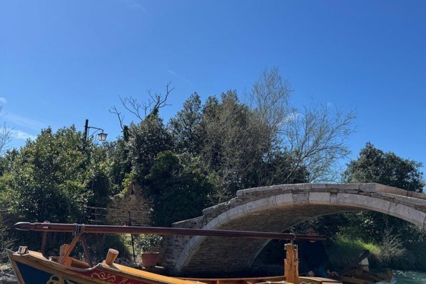 Eine Steinkonstruktion überspannt Wasser, ein hölzernes Boot liegt bereit und im Hintergrund dichte Vegetation. 3