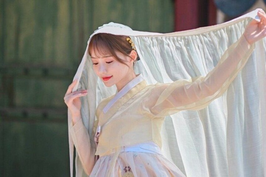 A person in traditional attire holding a white cloth. 2