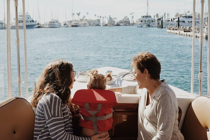 Three people on a boat with a marina in the background. 3