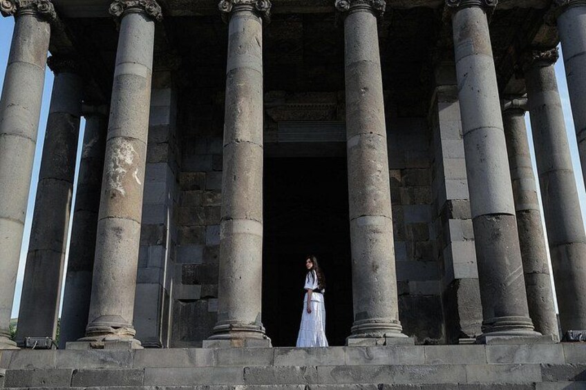 A person standing in front of ancient columns. 2