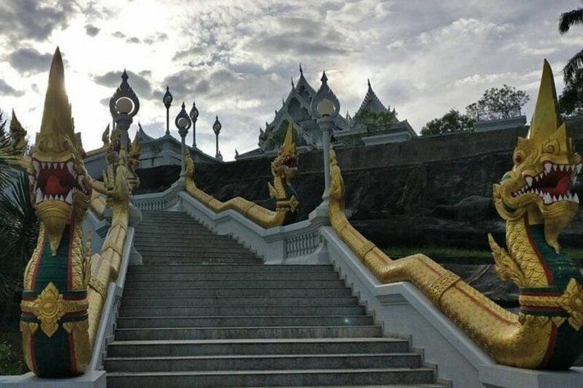 Een tempel met gedetailleerde gouden draken en een trap naar de ingang. 3