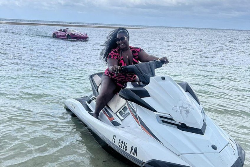 En person på en jetski med en pink sportsvogn i baggrunden. 1