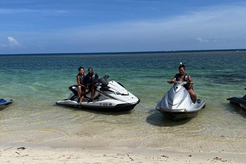 To jetski på en strand med klart vand og et fjerntliggende horisontlinje. 5