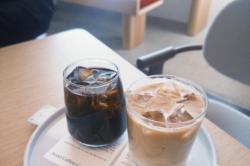 Two glasses of iced beverages on a tray with a menu. 4