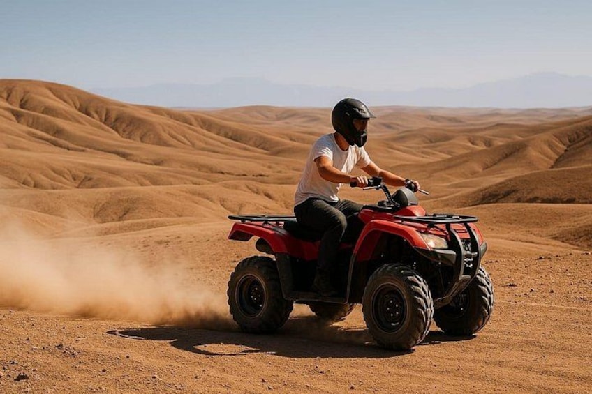 A person riding a red ATV on a desert terrain with undulating hills. 1