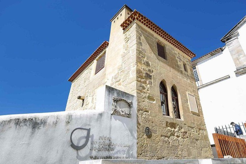 Un edificio in pietra con tetto a tegole, finestre ad arco e un piccolo balcone. 5