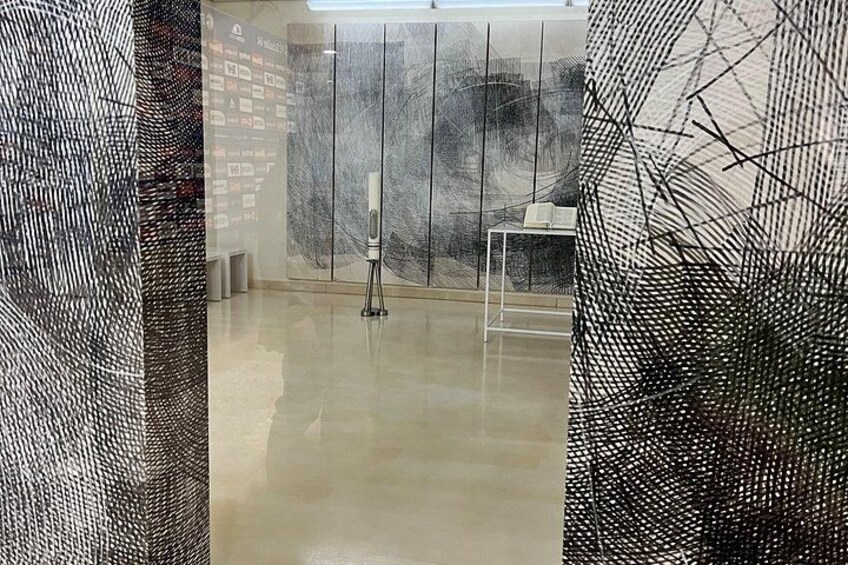 An art gallery with abstract paintings and a sculpture. 5