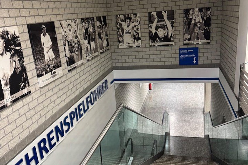 An indoor staircase with a sign reading 'THRENSPIELFÜHRER' and a blue directional sign above. 3