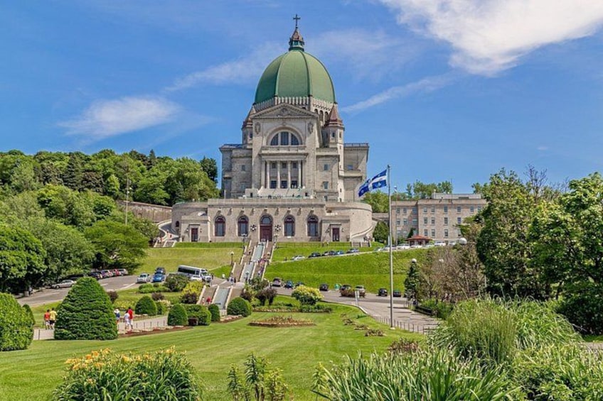 A large building with a green dome, surrounded by lush greenery and a well-maintained lawn. 2