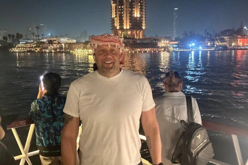 A person standing on a boat with a cityscape and water in the background. 3