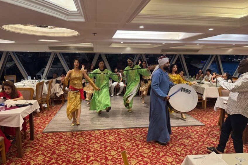 A group performing a traditional dance in a formal dining setting. 5