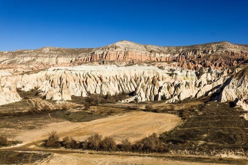 Un paisaje extenso con formaciones rocosas en capas y un camino de tierra. 2