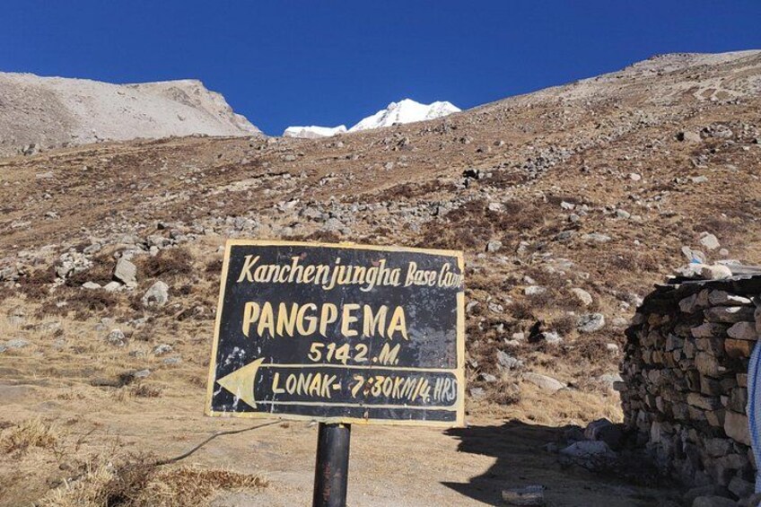 A signpost with directions to Kanchenjungha Base Camp and Pangpema, indicating a mountainous hiking trail. 2