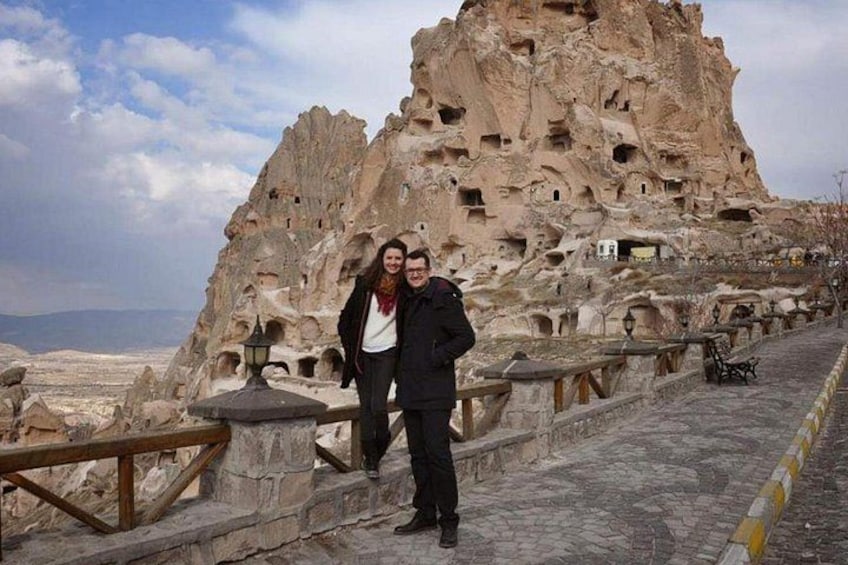 A rocky landscape with numerous cave dwellings and a paved walkway. 5