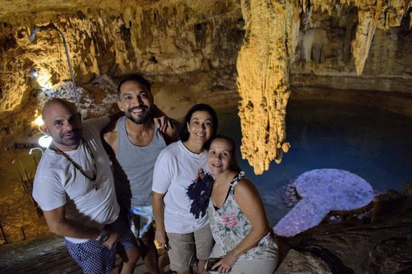 A group of people inside a cave with stalactites and stalagmites. 3