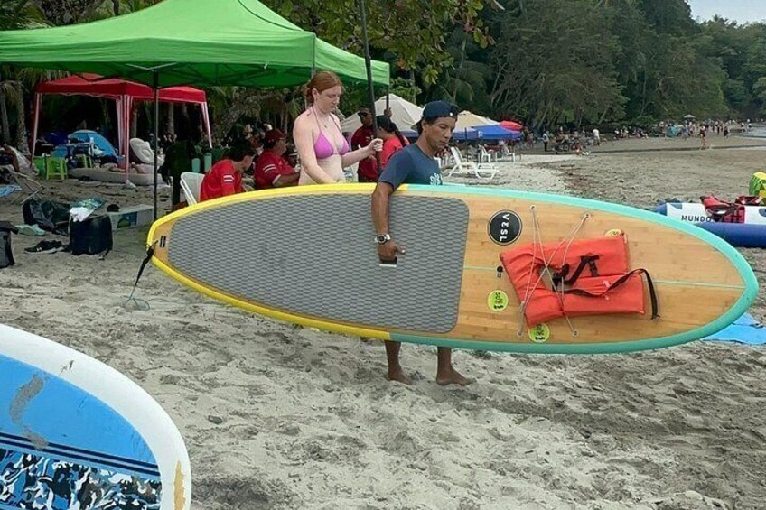 A beach scene with a surfboard, tents, and people. 5